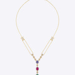 Featuring a layered gold chain with a gemstone cluster and teardrop-shaped green stone pendant.