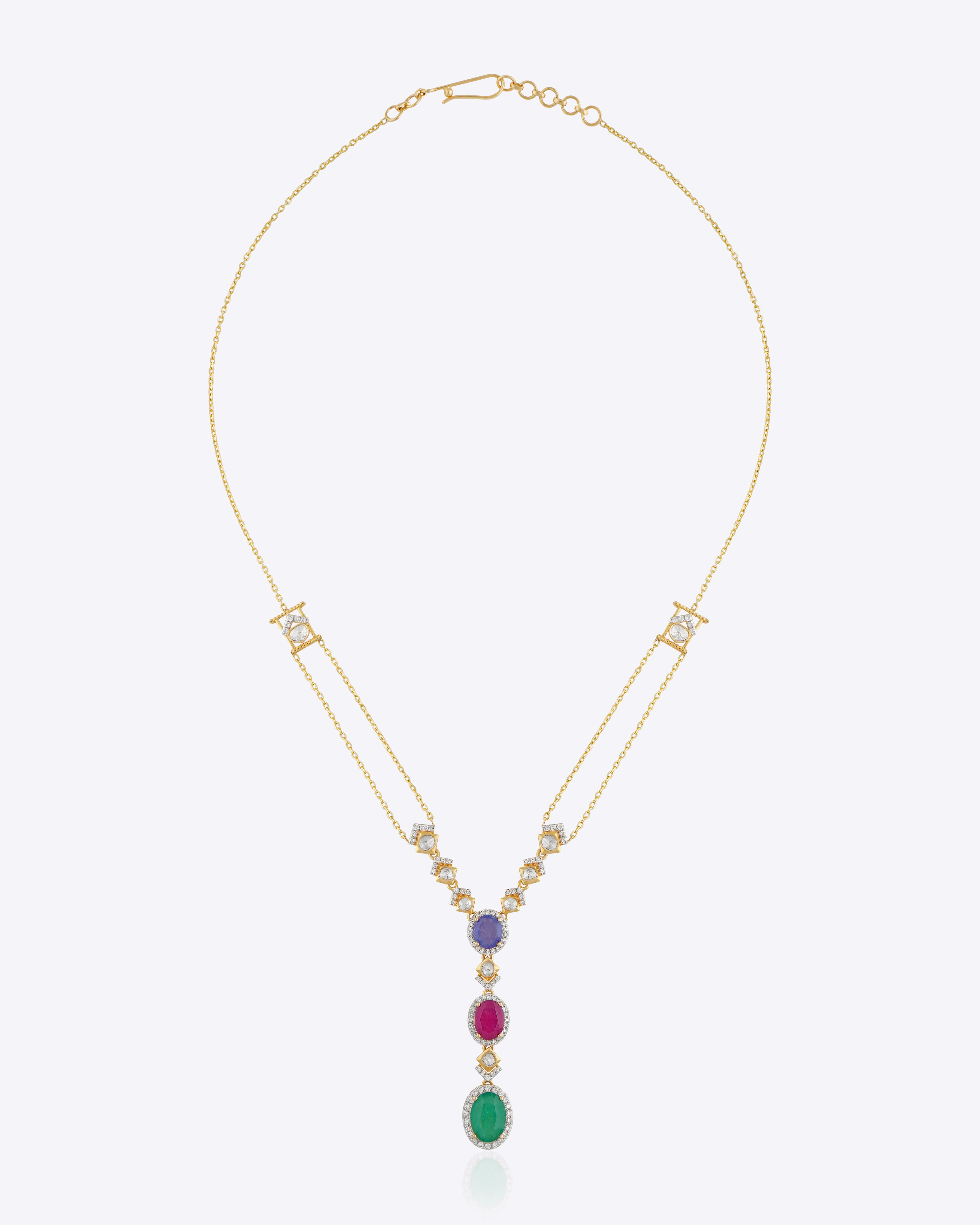 Featuring a layered gold chain with a gemstone cluster and teardrop-shaped green stone pendant.