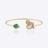Swan Symphony gold open bangle with Polki swan motif, blue gemstone accent and elegant craftsmanship.