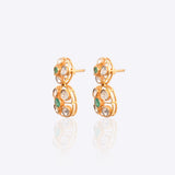 18K gold earrings with a central Polki diamond surrounded by vibrant emeralds.