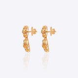 18K gold earrings with a central Polki diamond surrounded by vibrant emeralds.