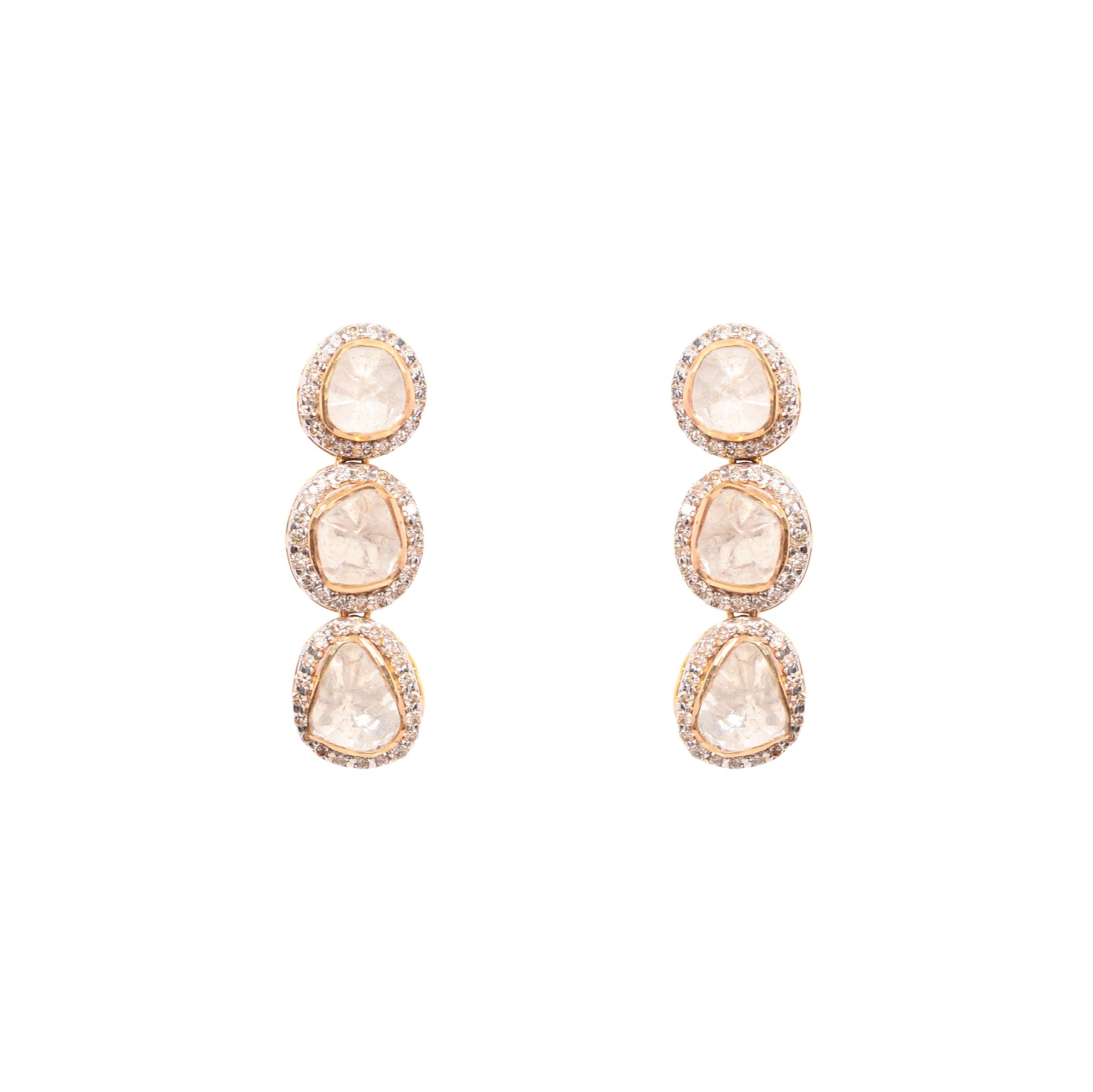 Elegant polki diamond drop earrings with classic silhouette displayed on champagne satin cloth.