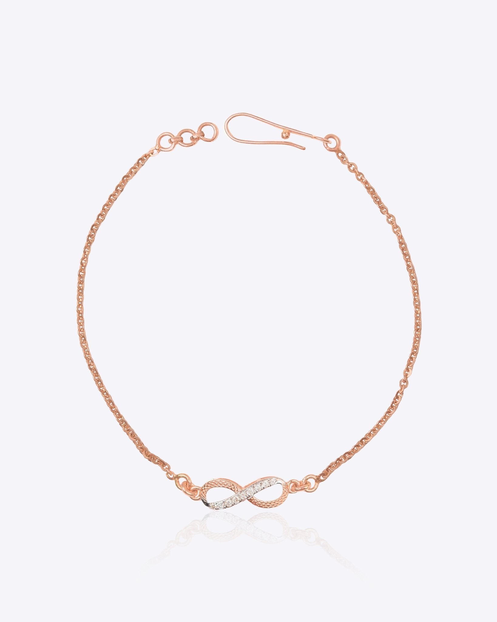 14K gold infinity motif bracelet with a diamond-studded design, worn solo.