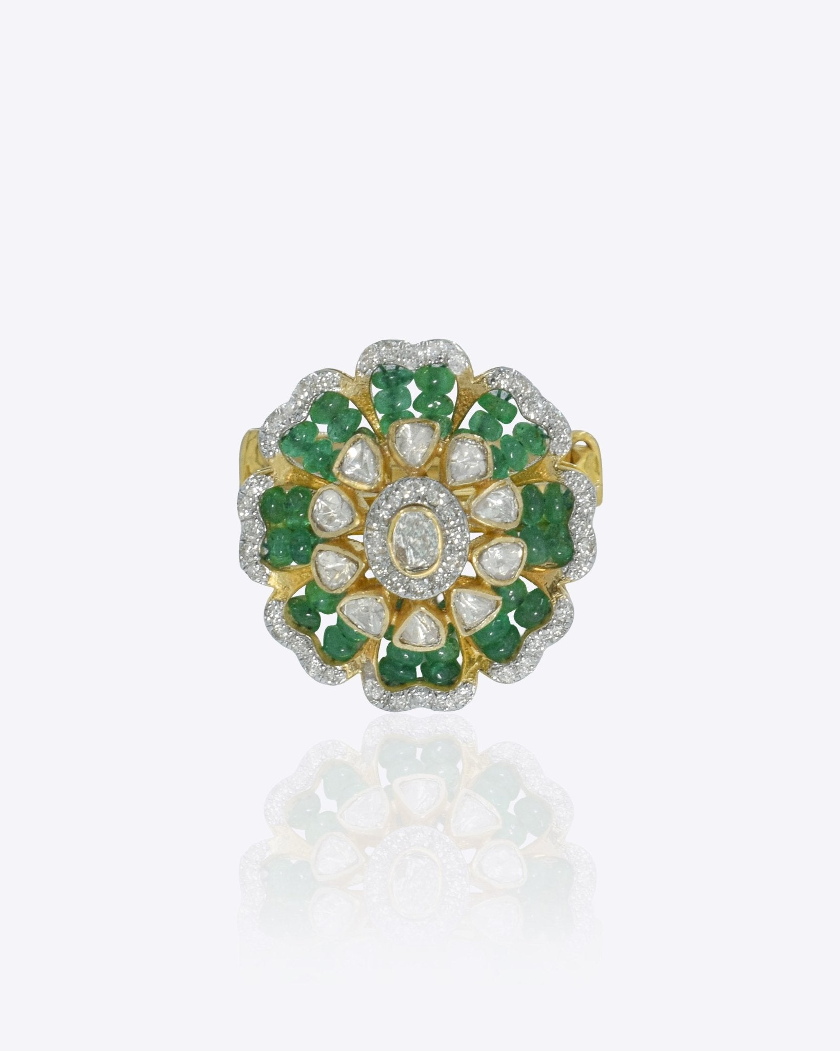 14k gold ring with a luminous Polki center and emerald accents.