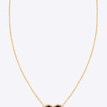 14k gold pendant with black and uncut diamonds in a delicate design.