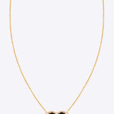 14k gold pendant with black and uncut diamonds in a delicate design.