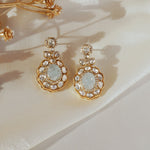 14K gold drop earrings with carved aquamarine centers and Polki diamond accents.