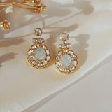 14K gold drop earrings with carved aquamarine centers and Polki diamond accents.