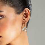Worn for a traditional celebration, these uncut stone earrings highlight timeless craftsmanship.