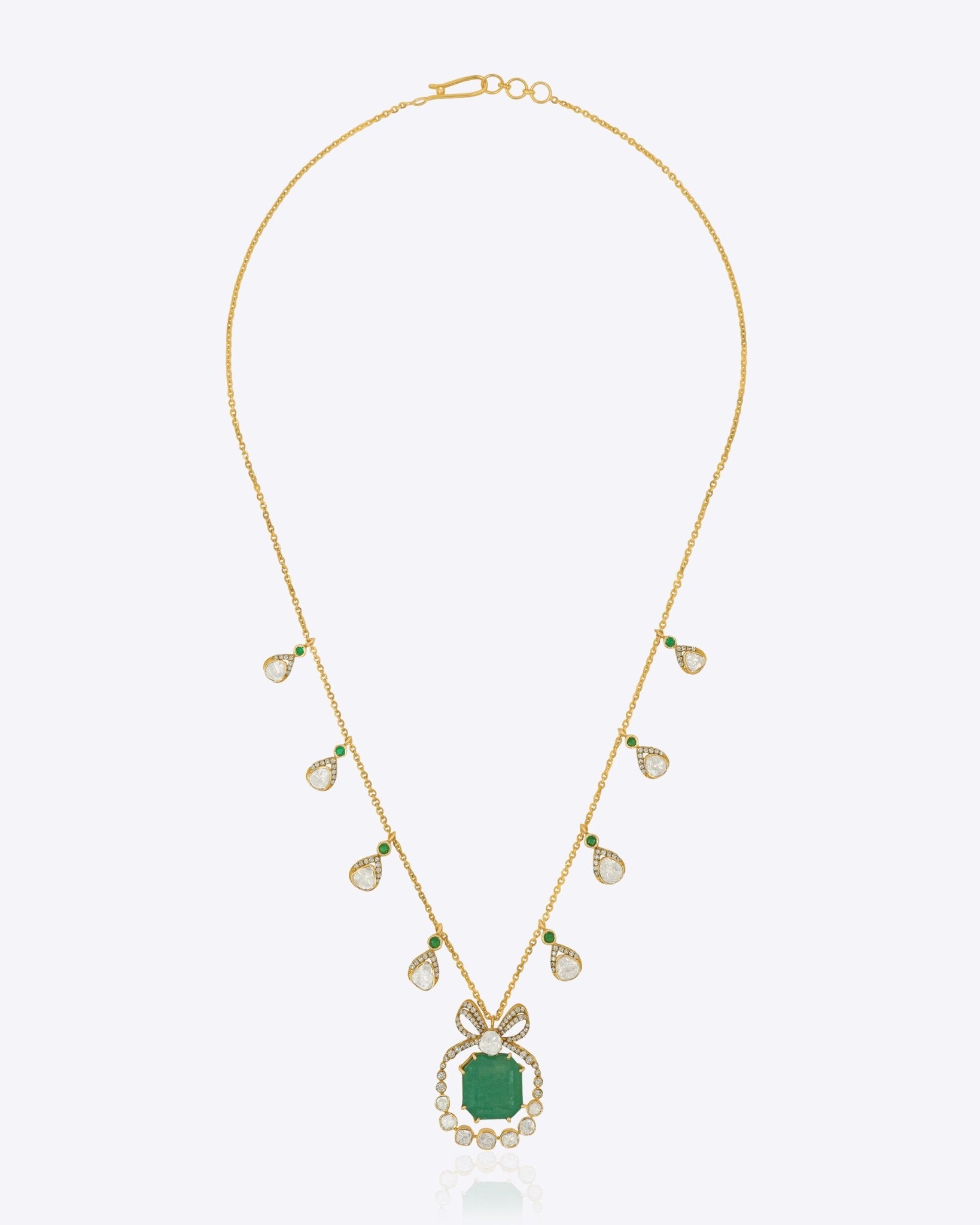 14K gold pendant with emerald centerpiece and diamond-studded bow