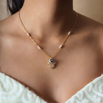 14k gold necklace with an Evil Eye and Hamsa symbol in diamonds