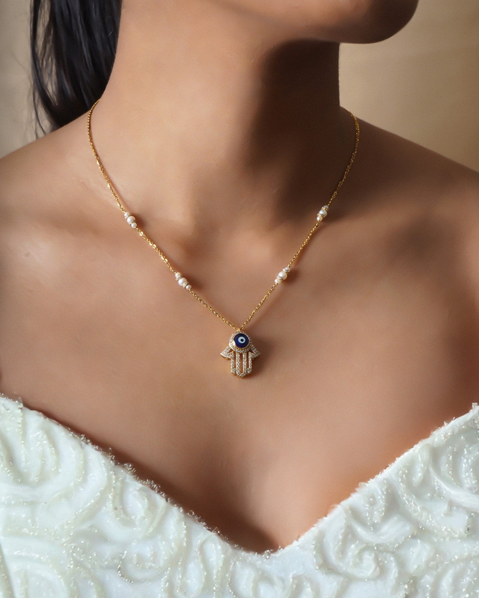14k gold necklace with an Evil Eye and Hamsa symbol in diamonds
