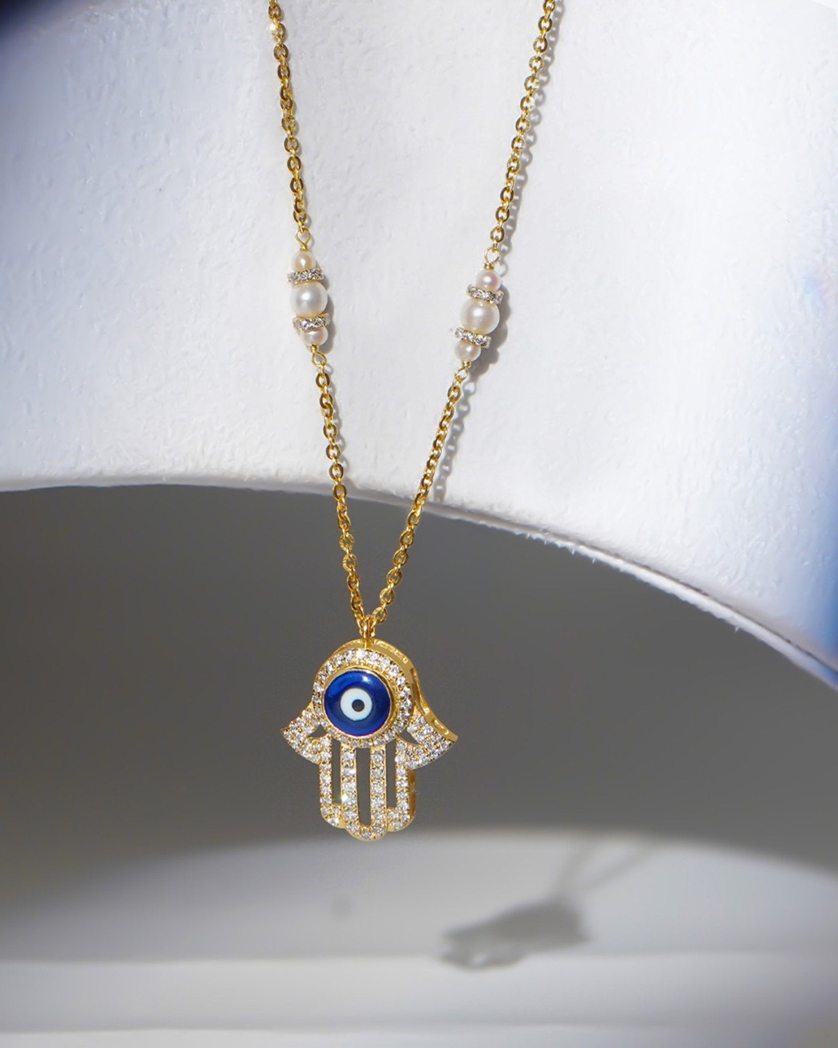 14k gold necklace with an Evil Eye and Hamsa symbol in diamonds