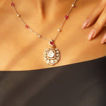 Rose-toned Polki pendant in 14K gold with soft pink stone drop, styled for evening wear.