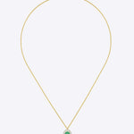 Oval emerald pendant in warm gold with a minimal, refined design