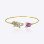 Firdous Leaf Bracelet in 9k gold open bypass bracelet featuring a Polki diamond vine and pink gemstone flower.