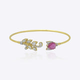 Firdous Leaf Bracelet in 9k gold open bypass bracelet featuring a Polki diamond vine and pink gemstone flower.