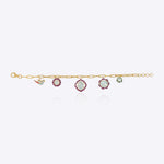 18K gold charm bracelet with floral motifs, talaf stones, and Polki accents.