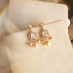 Jewelry image of pearl and polki fusion in wave-inspired frame.