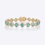 14k gold bracelet with an emerald centre and diamond halo
