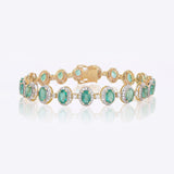 14k gold bracelet with an emerald centre and diamond halo