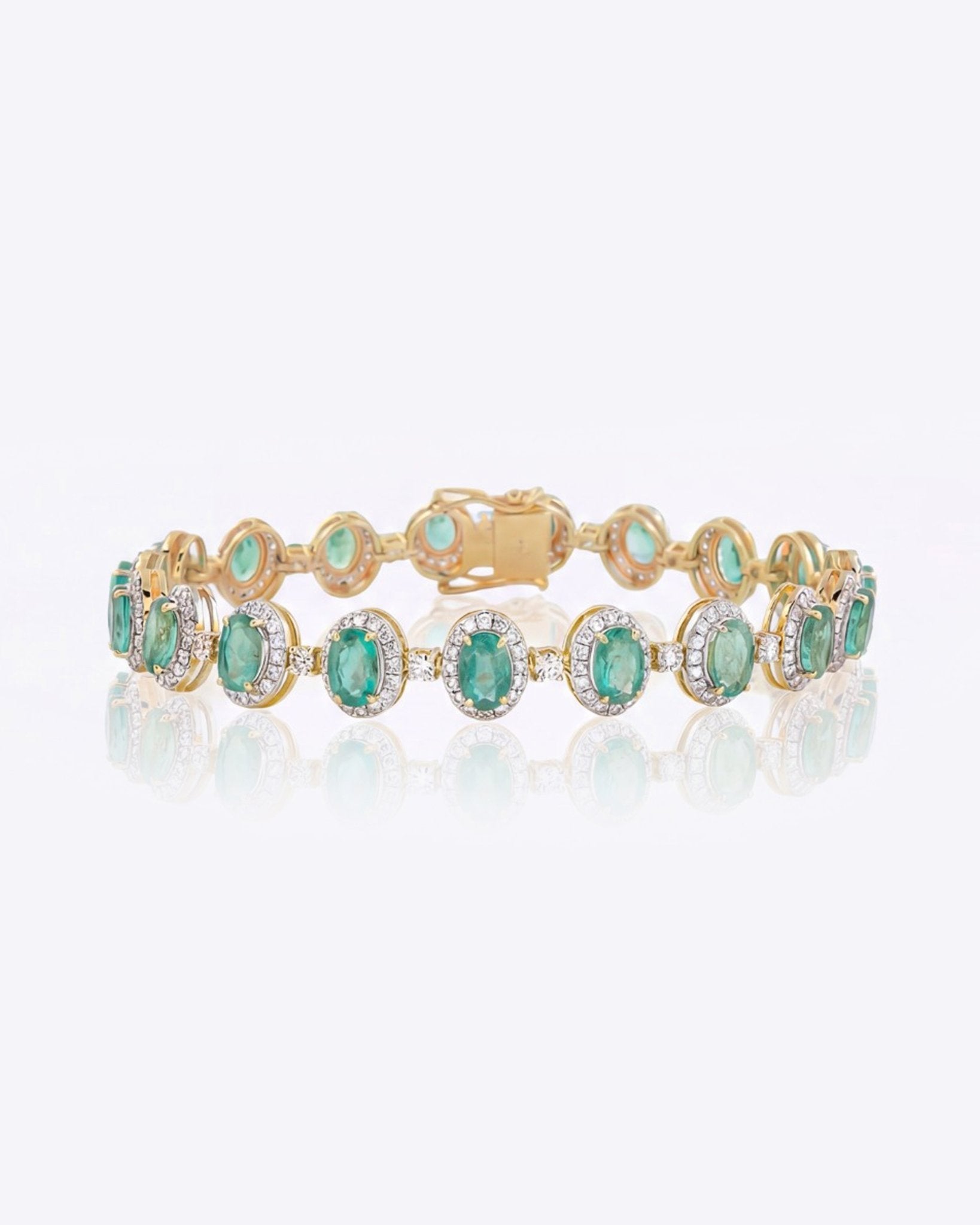 14k gold bracelet with an emerald centre and diamond halo